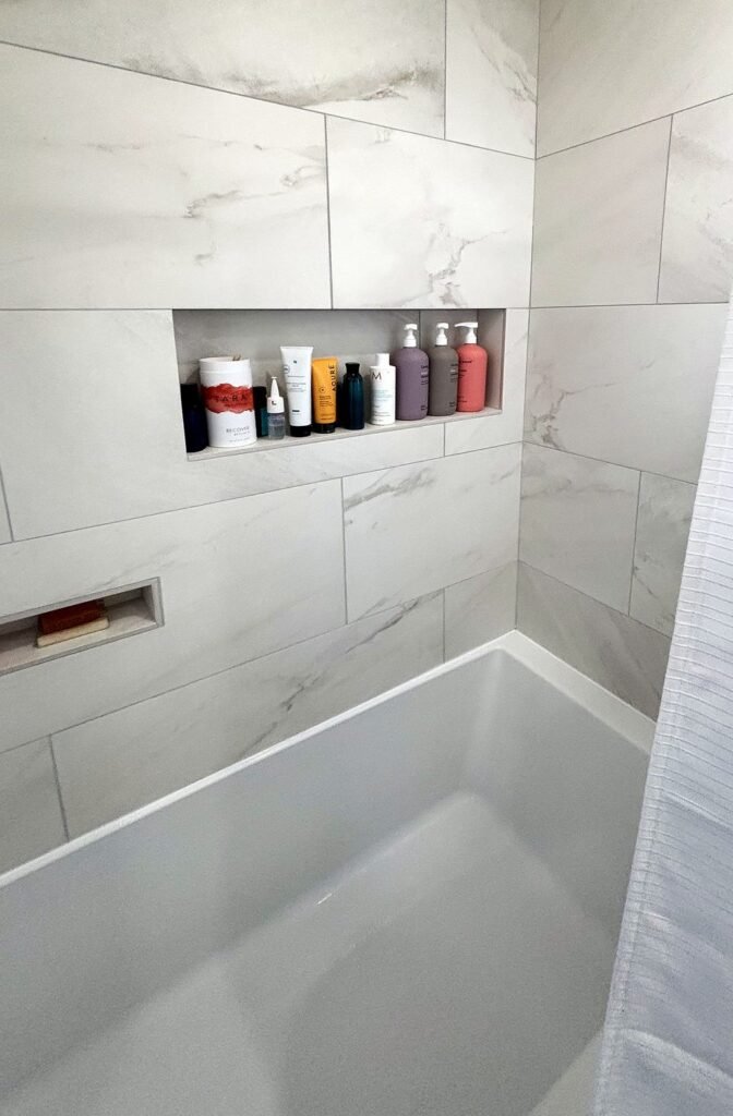 Bathroom remodel by Beehive Utah Contractor: large marble-look wall tile, two recessed shower niches, and a new alcove tub